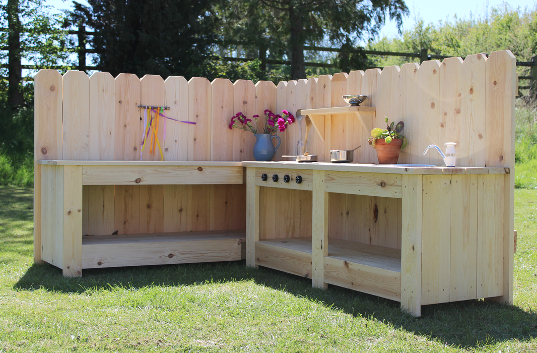 Wooden outdoor kitchen setup with a fence in the background