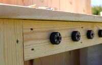 Wooden panel with black knobs on a blurred outdoor background